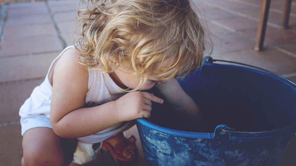 baby plating with a bucket