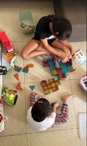 Children building structures with magnetic tiles during independent play at home
